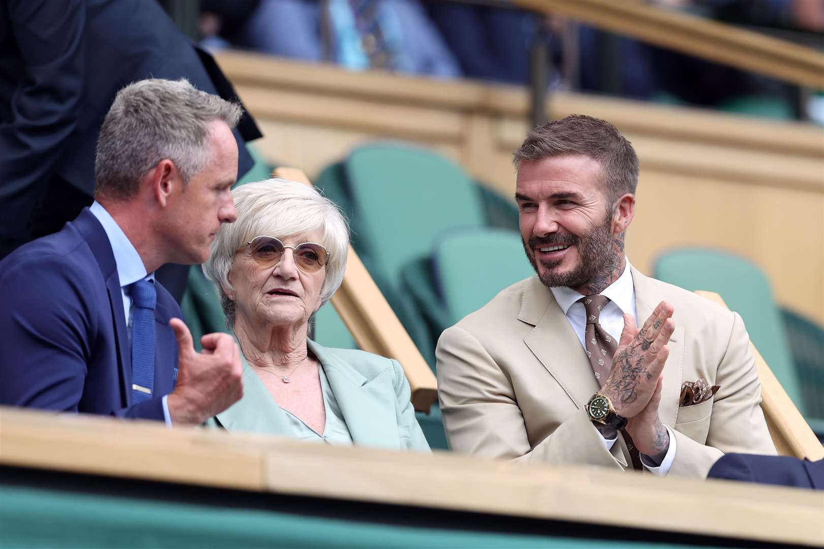 David Beckham greets Luke Donald as he takes his seat alongside his mother Sandra Beckham in the Royal Box of Centre Court (Steven Paston/PA)