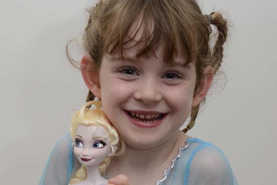 Ella Williams dressed as Queen Elsa from Frozen, holding her Queen Elsa doll. Picture: Paul Amos