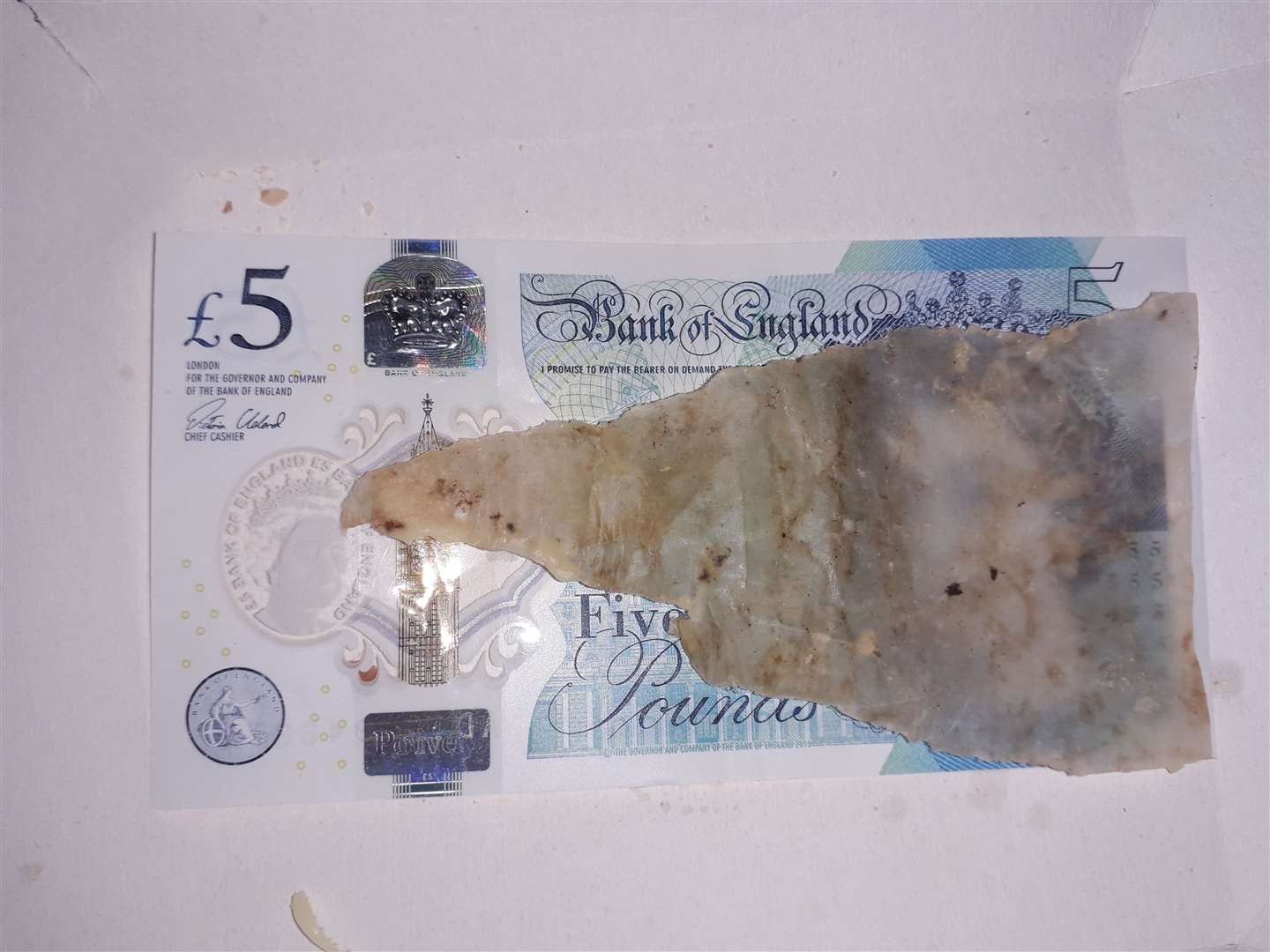 A £5 note alongside the rogue greaseproof paper, which somehow ended up in a Big Tasty with Bacon (9797359)