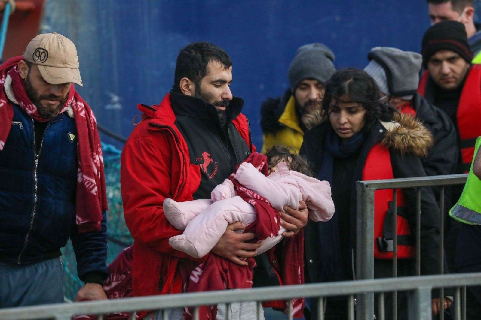 A baby is carried as part of one of the first group of asylum seekers brought ashore in 2022 Picture: UKNIP