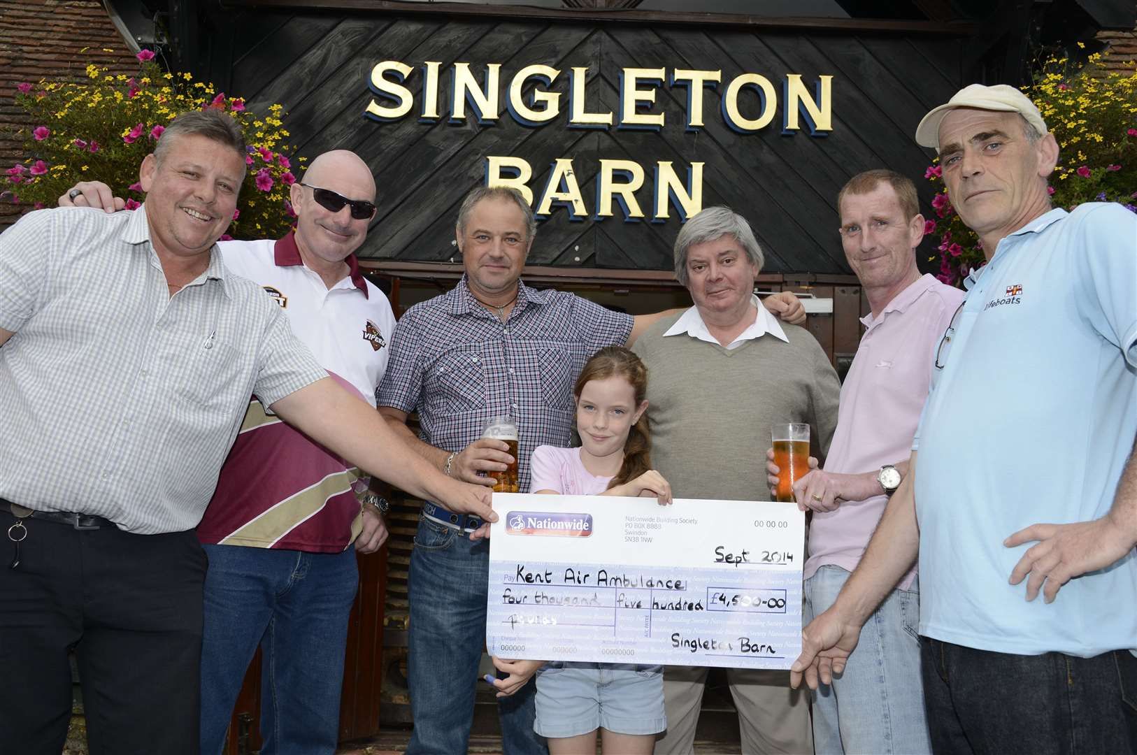 Mr Bispham, left, and pub regulars with a cheque they presented to the air ambulance in 2014