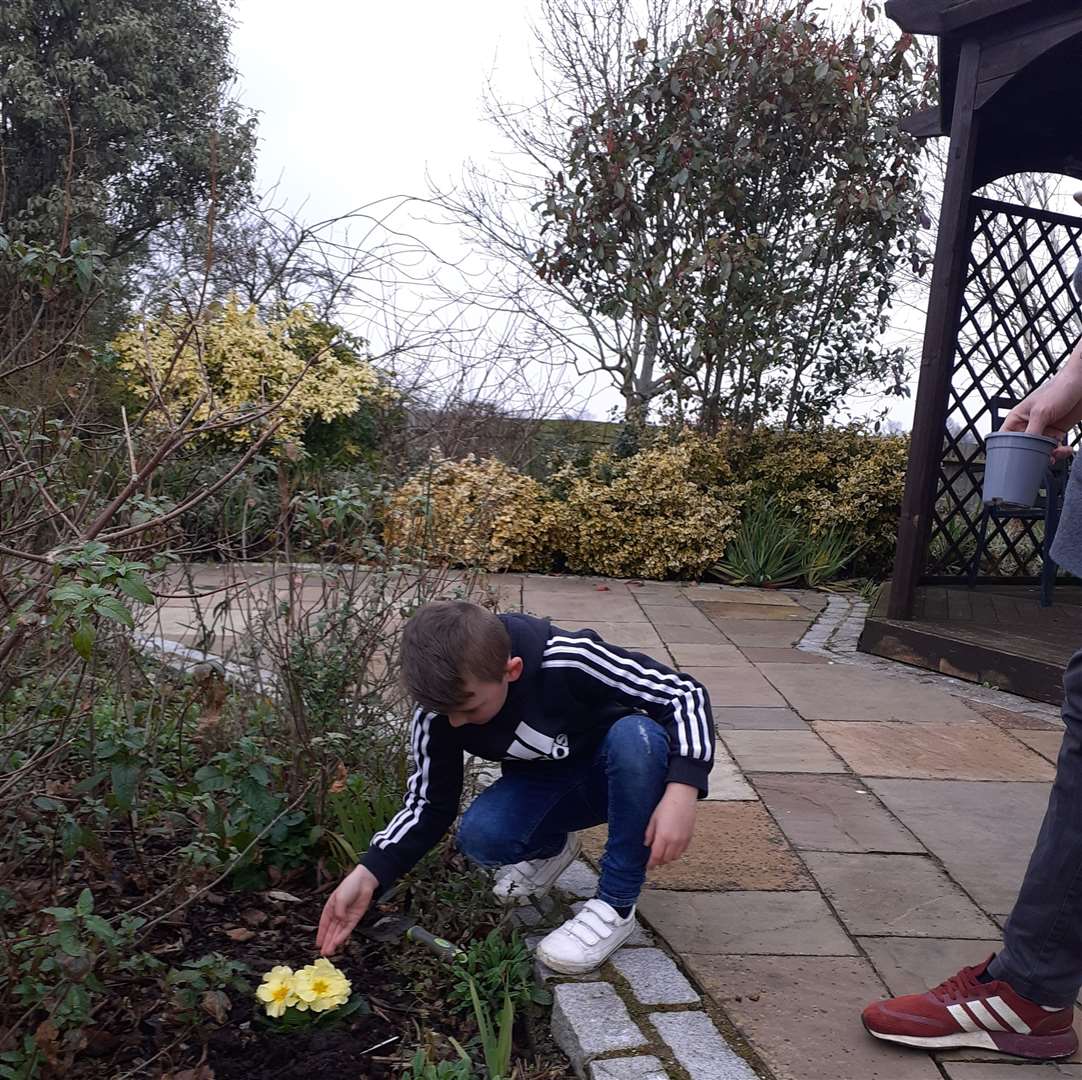 Ronnie Hawkings planting a flower in the hospice gardens in memory of his baby brother