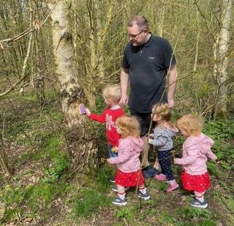 Jonny Springall with his son Francis, 4, two-year-old old twins Lucy and Amelia and their niece Nancy, 2, admiring the fairy doors in Newington, near Sittingbourne, before they were vandalised