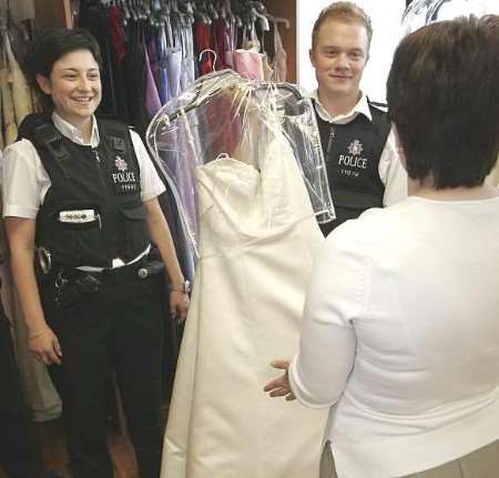 Police officers hand out bridal dresses to customers. Picture: PETER STILL
