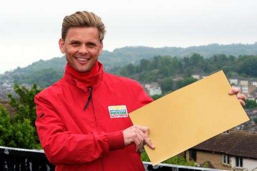Lottery ambassador Jeff Brazier holds the winners' golden envelopes. Picture: People's Postcode Lottery