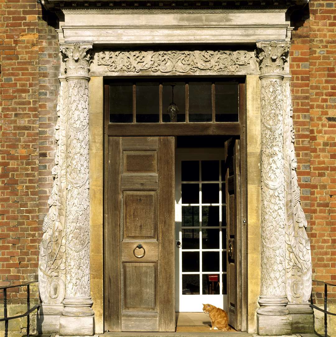 The partly open front door at Chartwell, the home of Sir Winston Churchill, with Jock the cat sitting in the sunshine Picture: National Trust Images, Rupert Truman