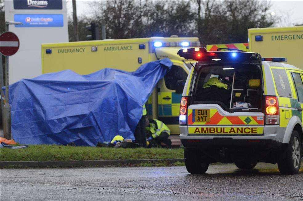A protective screen is put round the crash victim as doctors and paramedics work to stabilise him