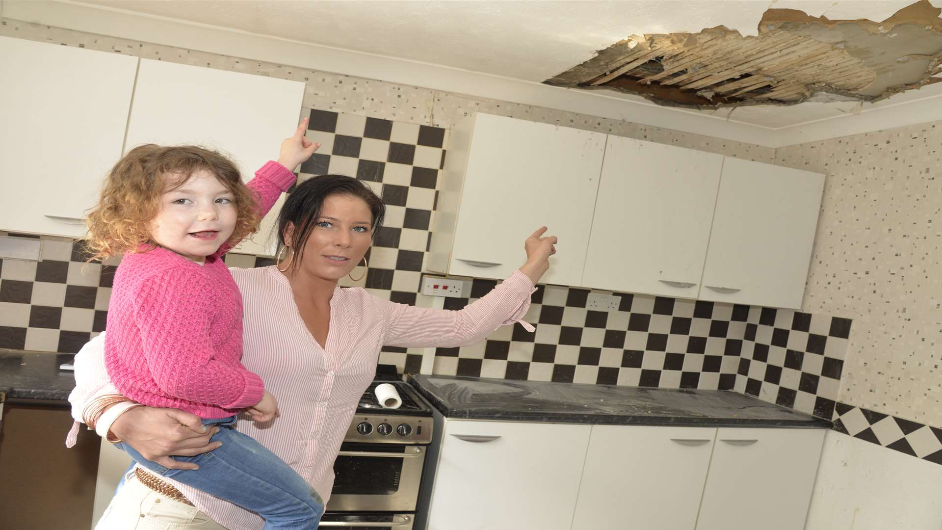 Paula and her daughter Roxanne Geiss, 4, look at a hole in the ceiling which is due to a leaking water tank. Picture: Ruth Cuerden