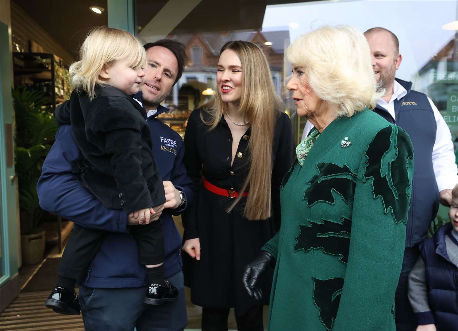 Camilla meets the owner of Knotts Bakery, William Corrie, his wife Zoe Salmon and their son Fitz during the visit to Belfast (Liam McBurney/PA)