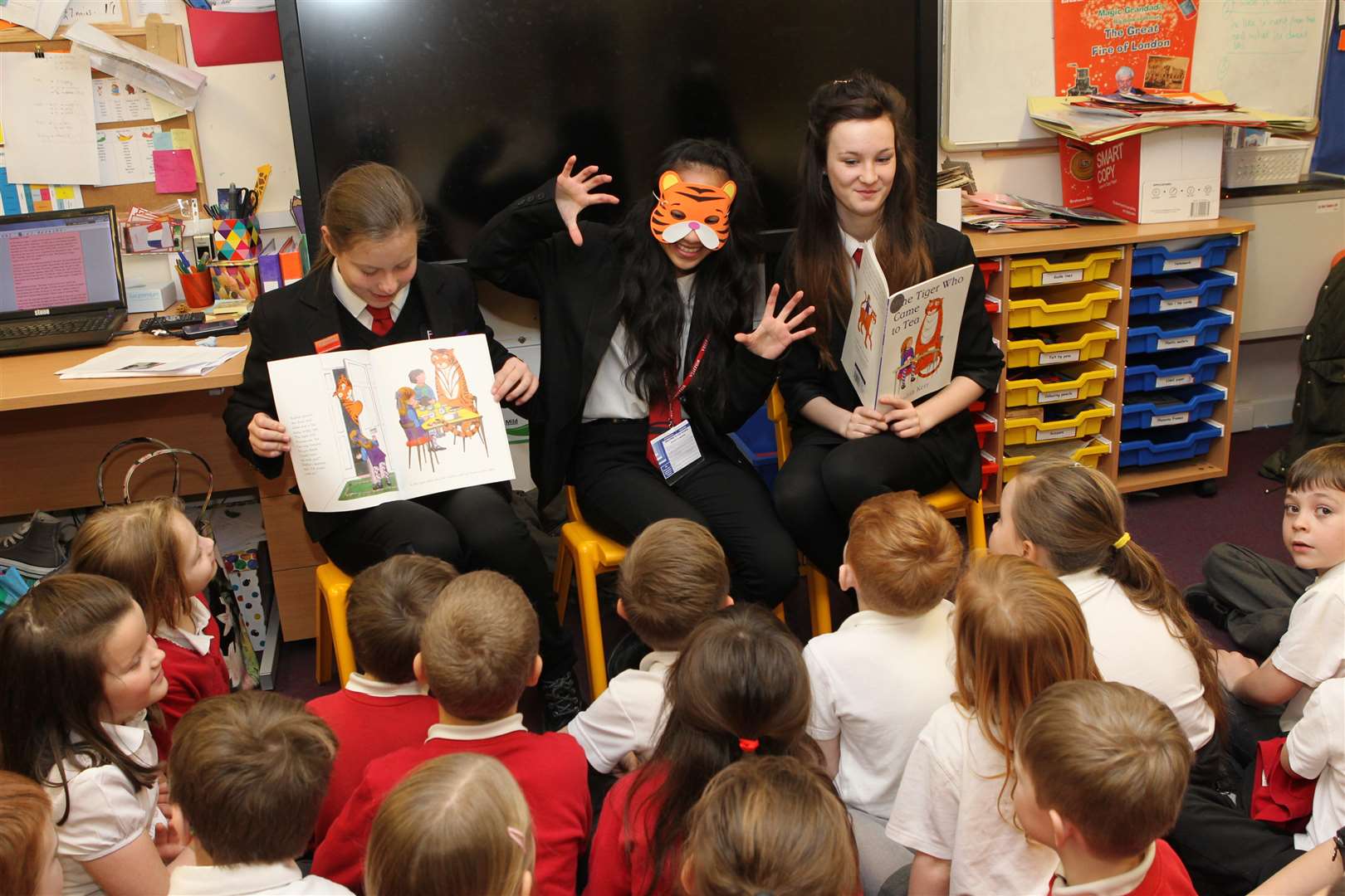 Erin Chappell, 13, Zhanelle Morgan and Megan Poultney, both 14 read and act out the Tiger Who Came to Tea story in front of a Year two class at Queenborough Primary School