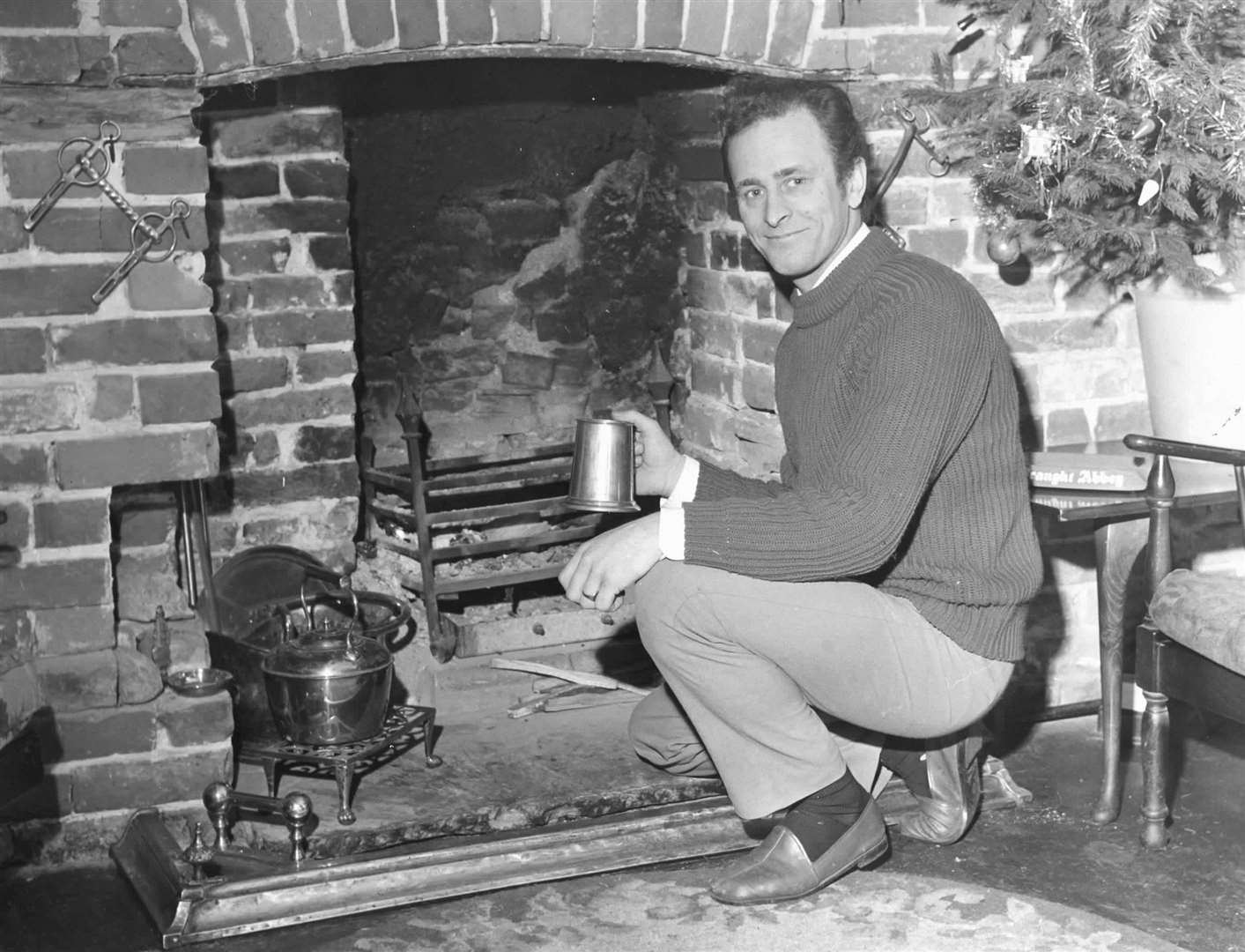 Brian Russell, landlord of The Royal Oak, pictured with an old fireplace he had uncovered in December 1973