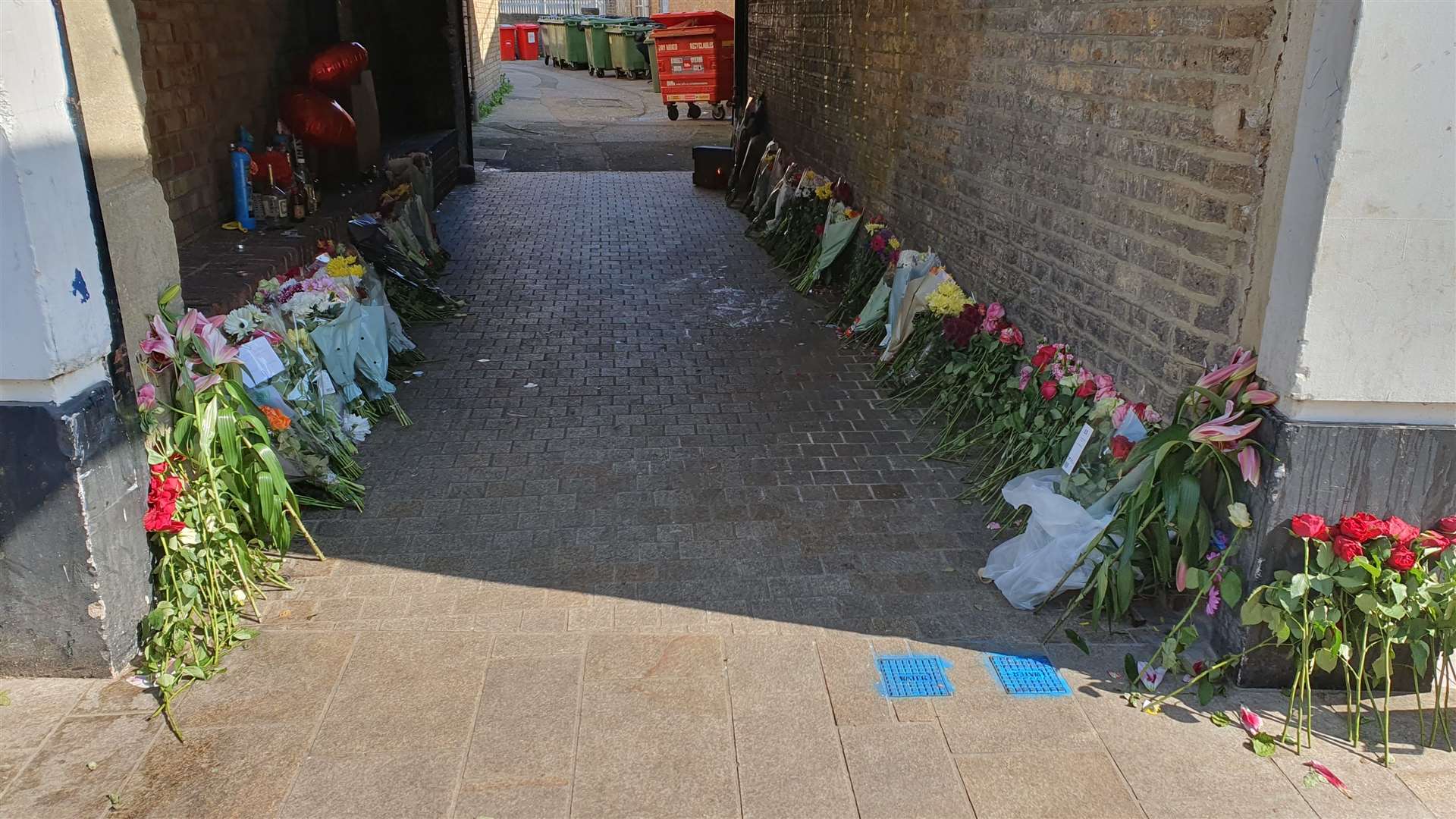 Tributes to an 18-year-old stabbing victim line the alleyway in Dartford High Street