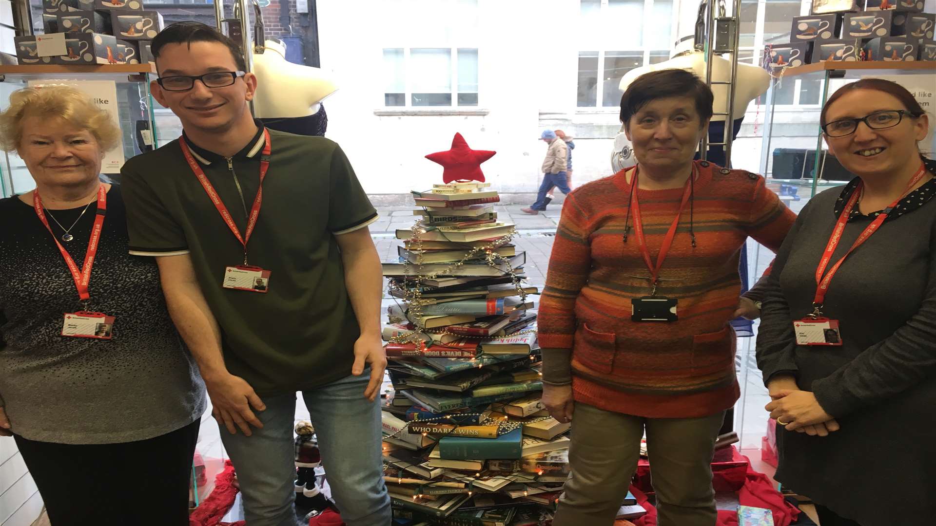 Staff at Gravesend's British Red Cross charity shop, next to their unique Christmas tree