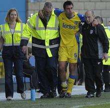 Garry Richards is helped away from the pitch after getting injured