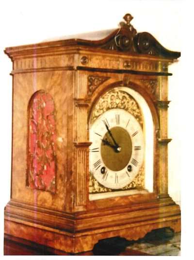 The German Lenzkirch wooden clock which dates back to the early 20th century and is about 12 inches high