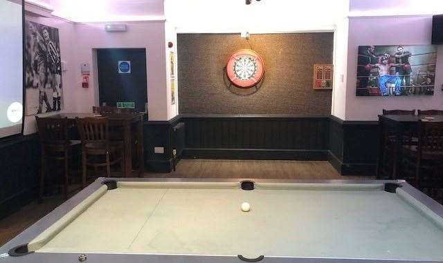 The pool table, which takes pride of place in the games room to the left, is covered with grey cloth