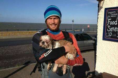 Water sports instructor Charlie Head with a dog he pulled from the waves off Hampton