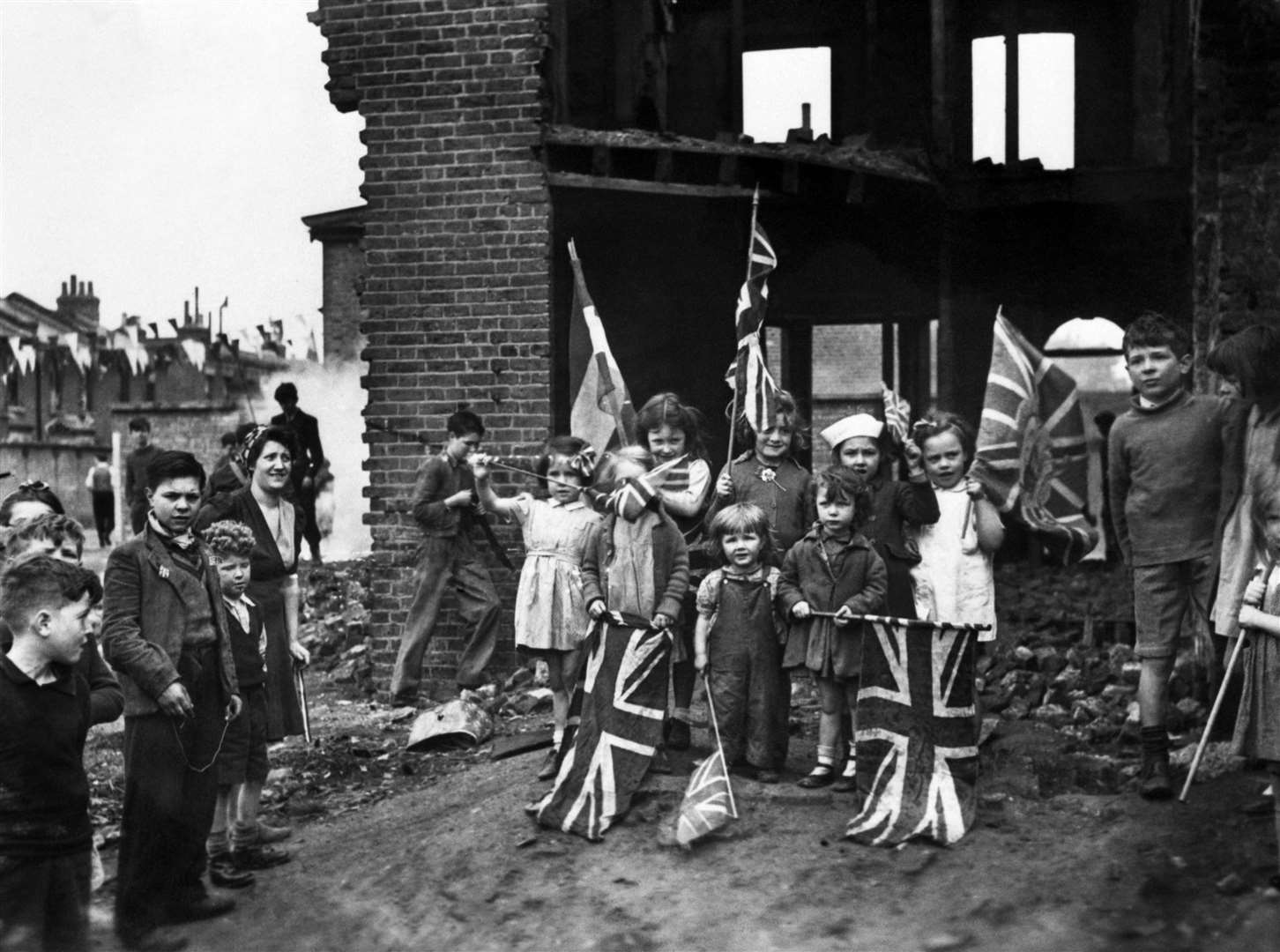 Young residents celebrate VE Day in the ruins of their home in Battersea (PA)