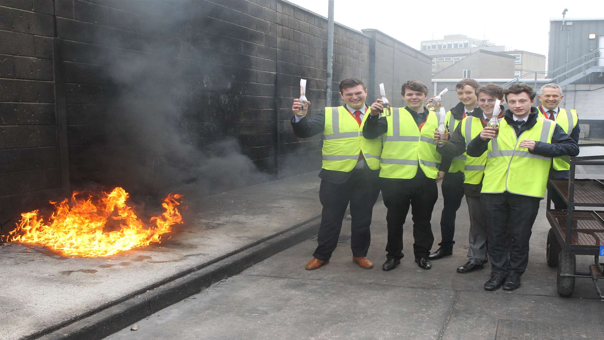 Sixth formers from The Leigh UTC with headteacher, Steve Leahey, stand with petrol bombs and the trolley