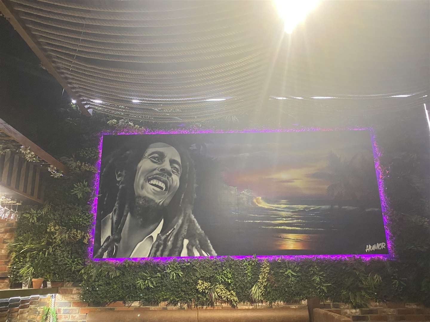 A huge mural of Bob Marley is looking down on the restaurant floor