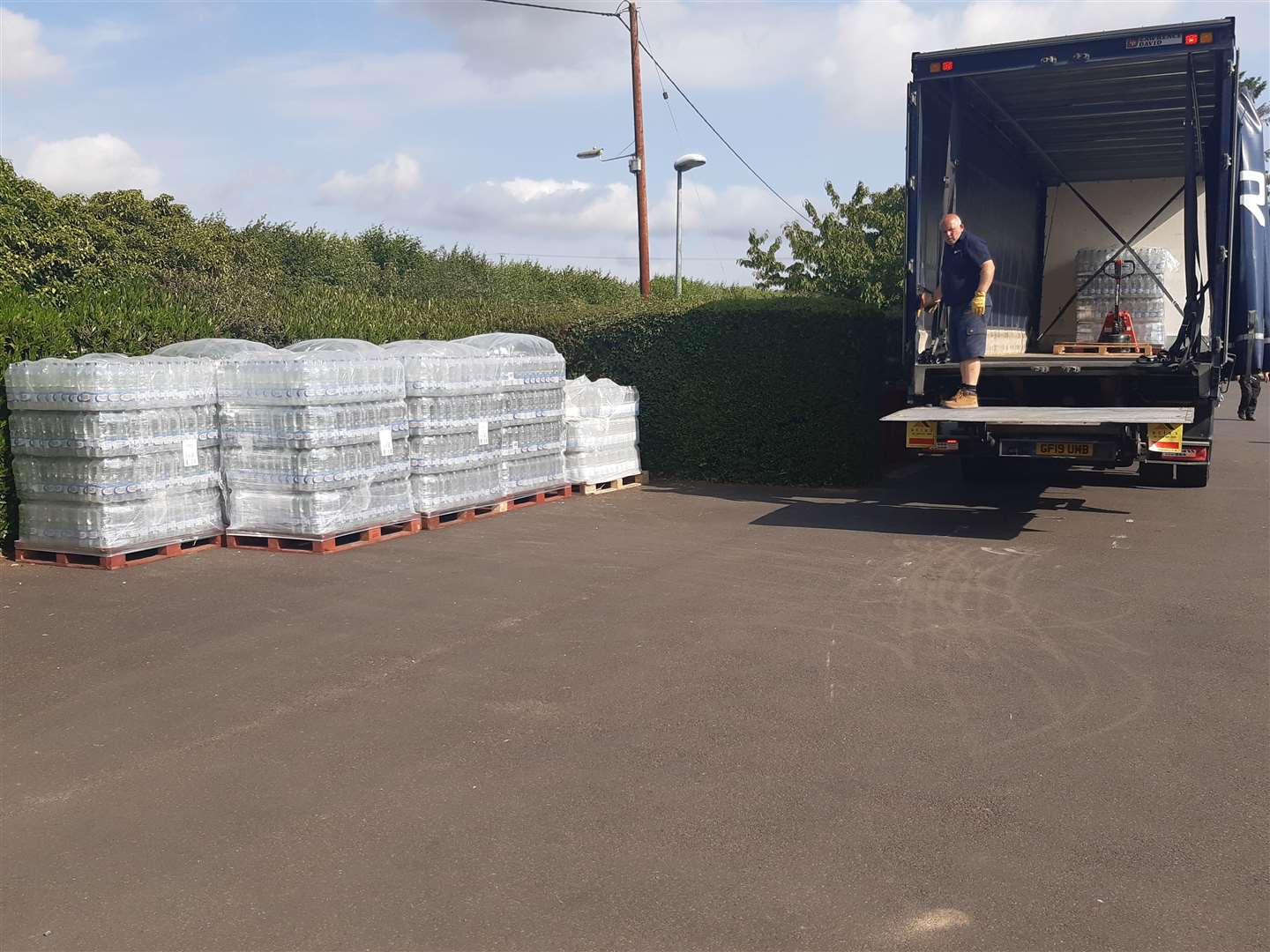 Pallets of water wait to be distributed in East Peckham