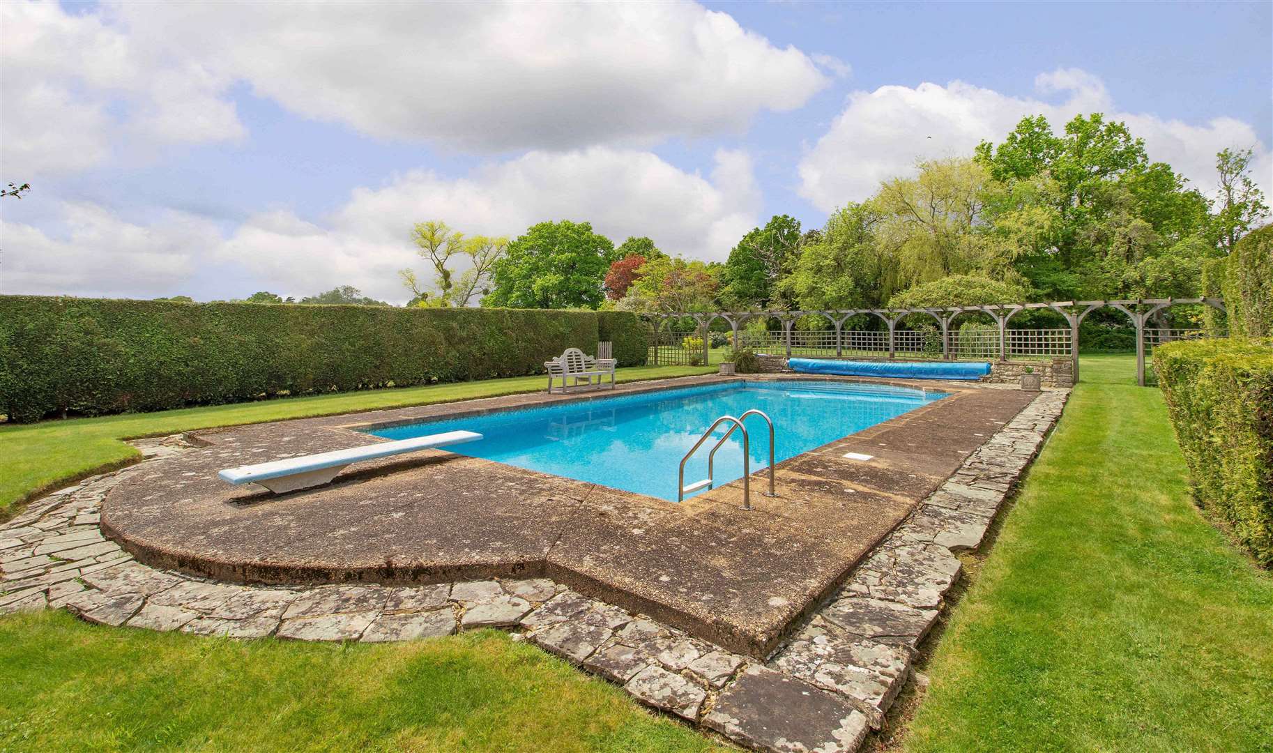 The outdoor pool is heated and tucked away behind the hedging. Picture: Savills