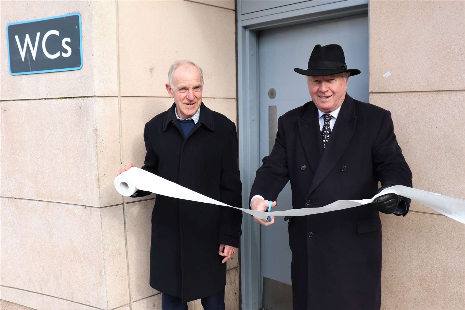 Councillors' John Collier (L) and David Monk (R) cut the 'ribbon' to open the town centre toilets
