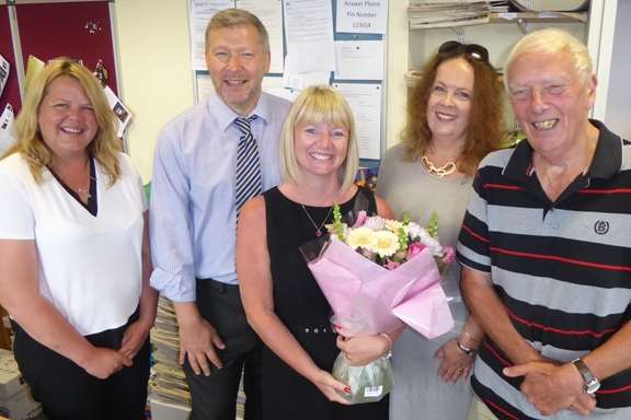 KM Charity Team Team Leader Karen Brinkman is presented with a bouquet to celebrate 10 years of service with the charity by past and present staff and trustees. Left to right: Teresa Curteis, Simon Dolby, Katie McDaniel and Martin Vye.