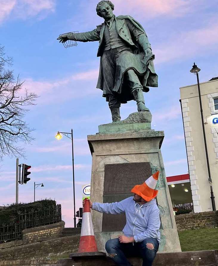 James Hutch sitting in front of the Thomas Waghorn statue for his last music video