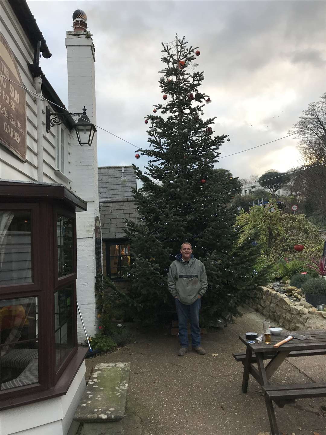 Dan Johnson with the 24ft tree outside The Rising Sun pub in Kingsdown