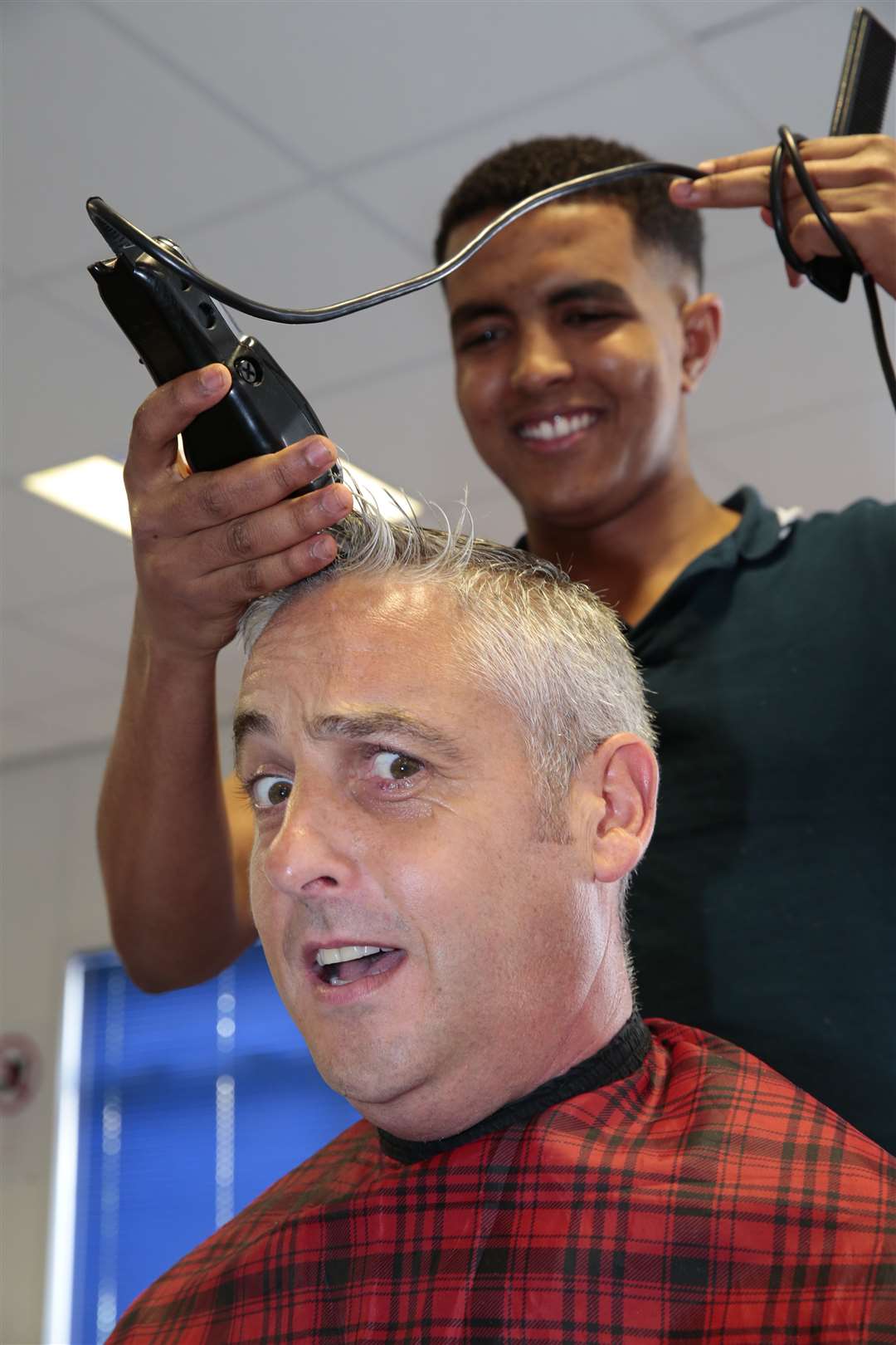 Rob Devonald has his head shaved by Harry from Goldscissors. Picture: Martin Apps