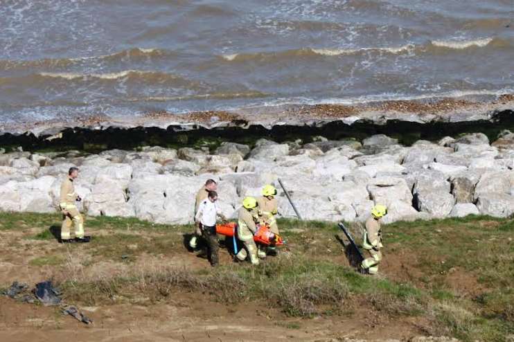 A woman is carried to safety after getting stuck in mud on the Isle of Sheppey.