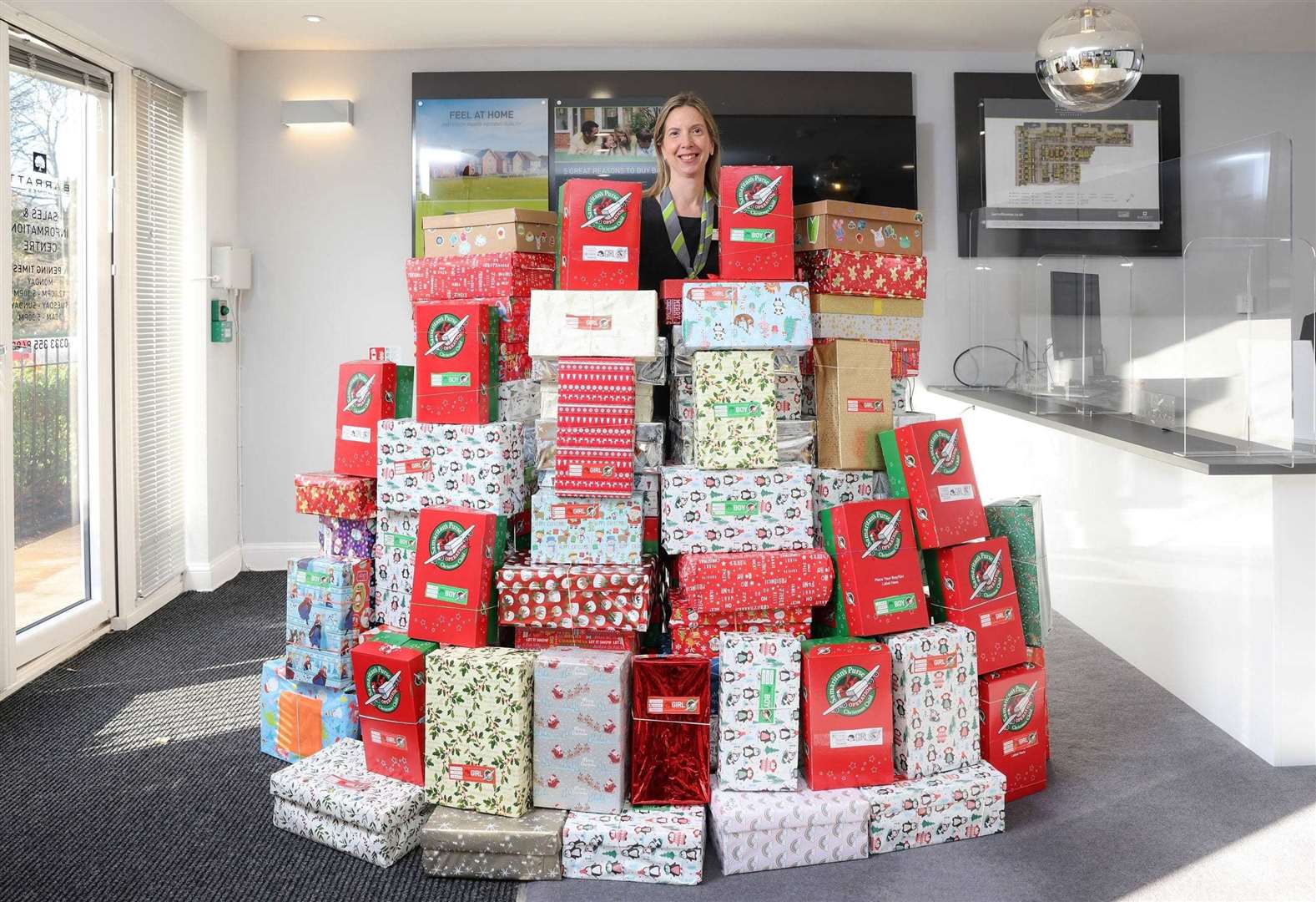 Some of the hundreds of shoeboxes donated. Shown with them is Barratt Homes sales adviser Lynn Alexander, Picture: Barratt Homes