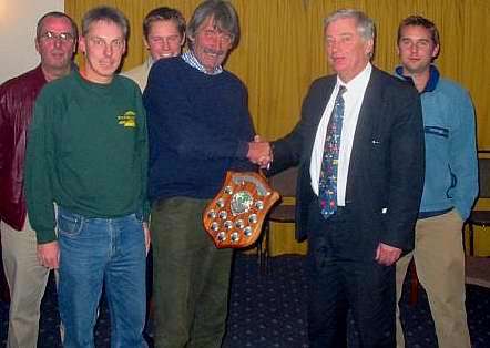 CELEBRATION TIME: League chairman Archie Wright presents the trophy to Hythe skipper Nigel Pichowski, flanked by players, from left, Roger Mapstone, Paul Goddard and Martin Ritchie, and retiring secretary Kevin Hall, second left