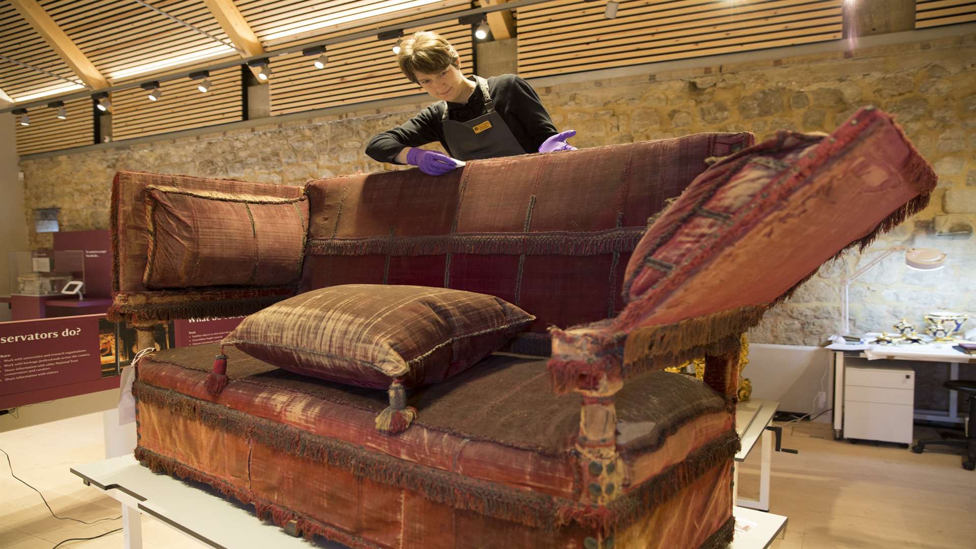 Senior Conservator Heather Porter cleans the velvet of the Knole sofa with a cosmetic sponge. Picture: National Trust, James Dobson