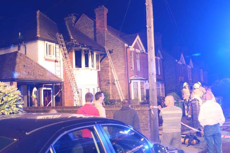 People gather at the scene of a house fire in Maidstone