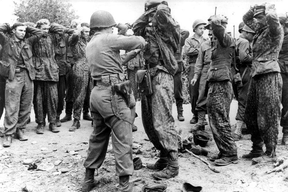 American soldiers search German prisoners from a Waffen SS Division at Gavray, Normandy, in the wake of the D-Day Landings of June 1944