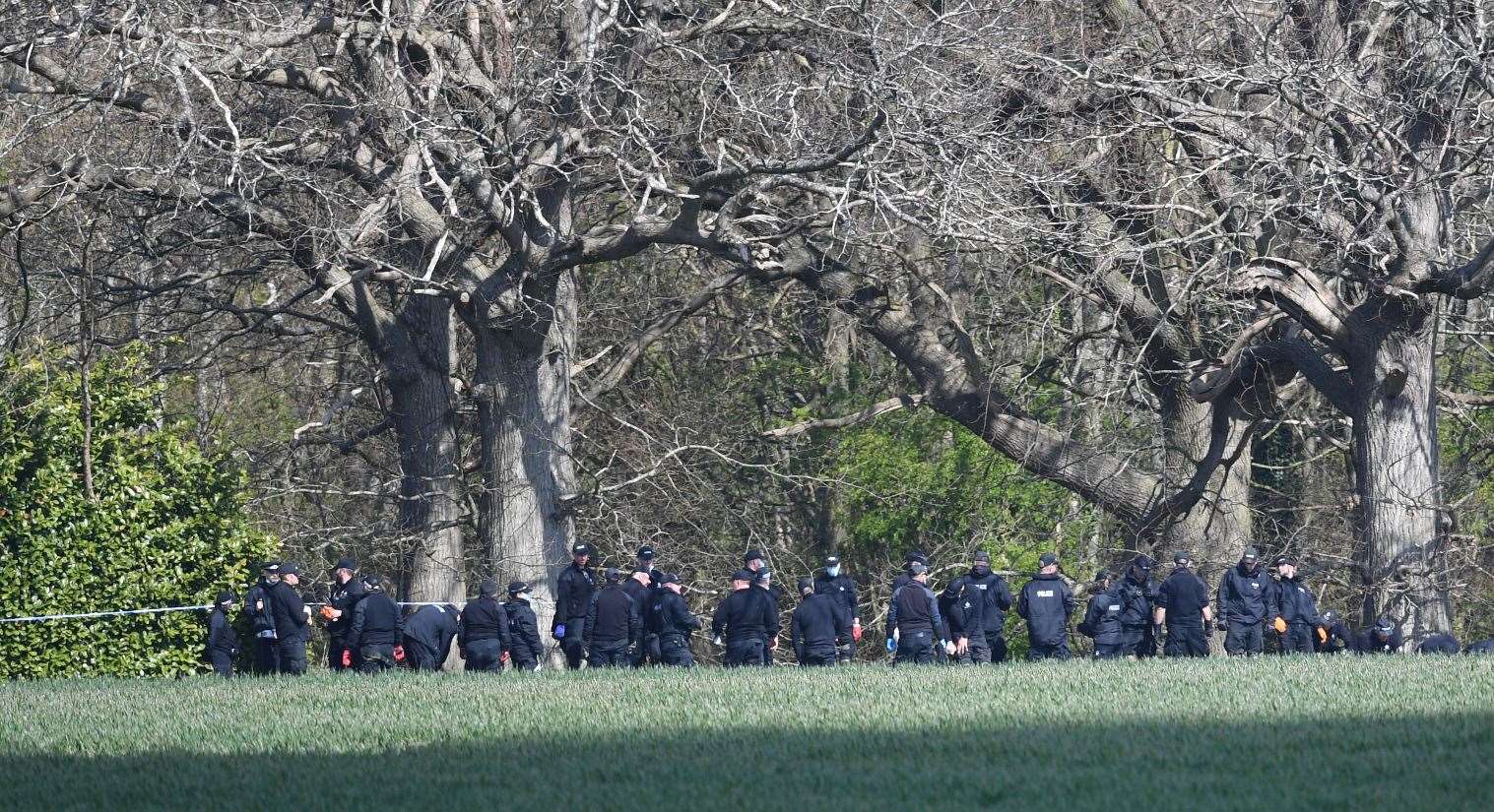 Police officers search a field close to where Ms James’s body was found (PA)