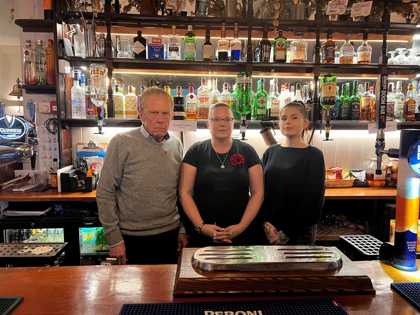 Chris Porter, 76, with The Harrow manager, Sarah Reeves, 40, and barmaid Mia Hayes, 25. Picture: Megan Carr