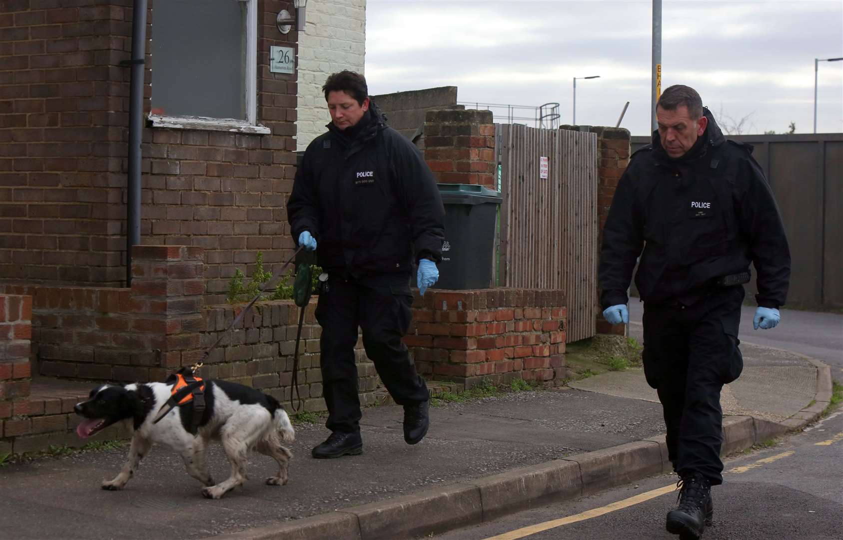 A sniffer dog and specialist officers searching land around Hamerton Road, Northfleet