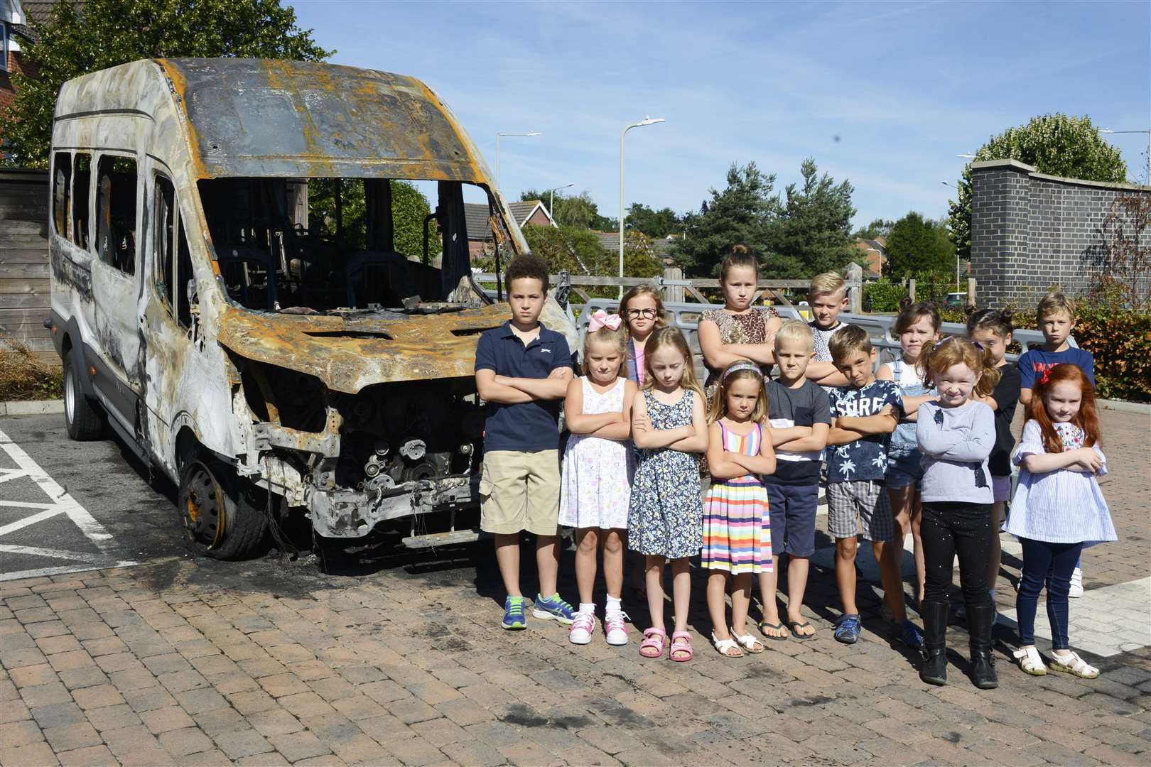 Primary school children standing by the burnout vehicle. Picture: Paul Amos