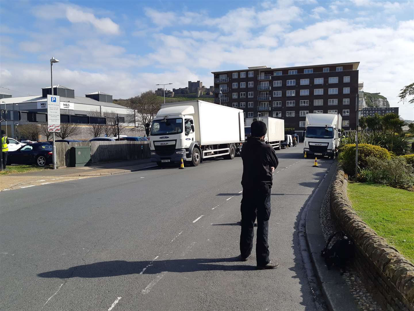 A security guard keeps watch at the location at Camden Crescent. Film crew lorries are also seen