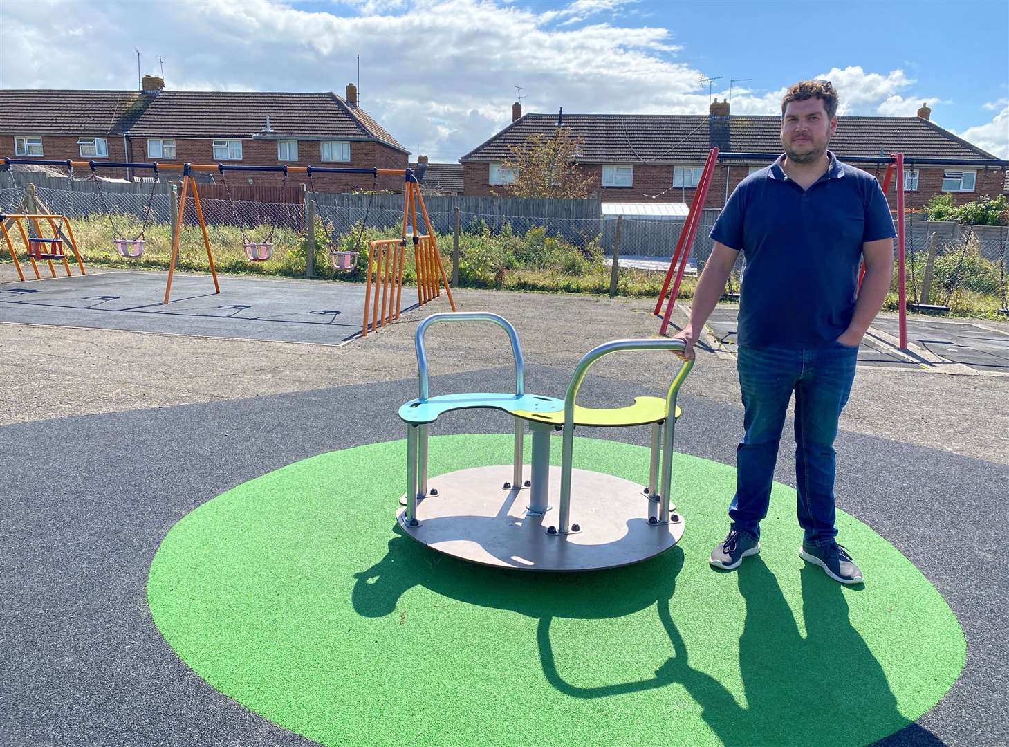 Cllr Elliott Jayes with the new low platform roundabout at New Road playground in Minster