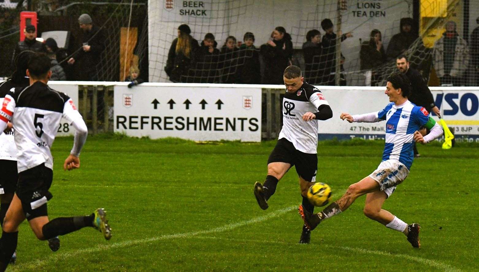 Faversham's Matt Parsons clears in front of Sheppey's Billy Bennett. Picture: Marc Richards