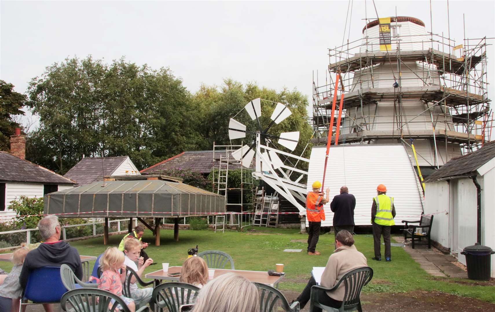 Volunteers watched as the restored cap was hoisted back into place. Picture: The White Mill Rural Heritage Centre