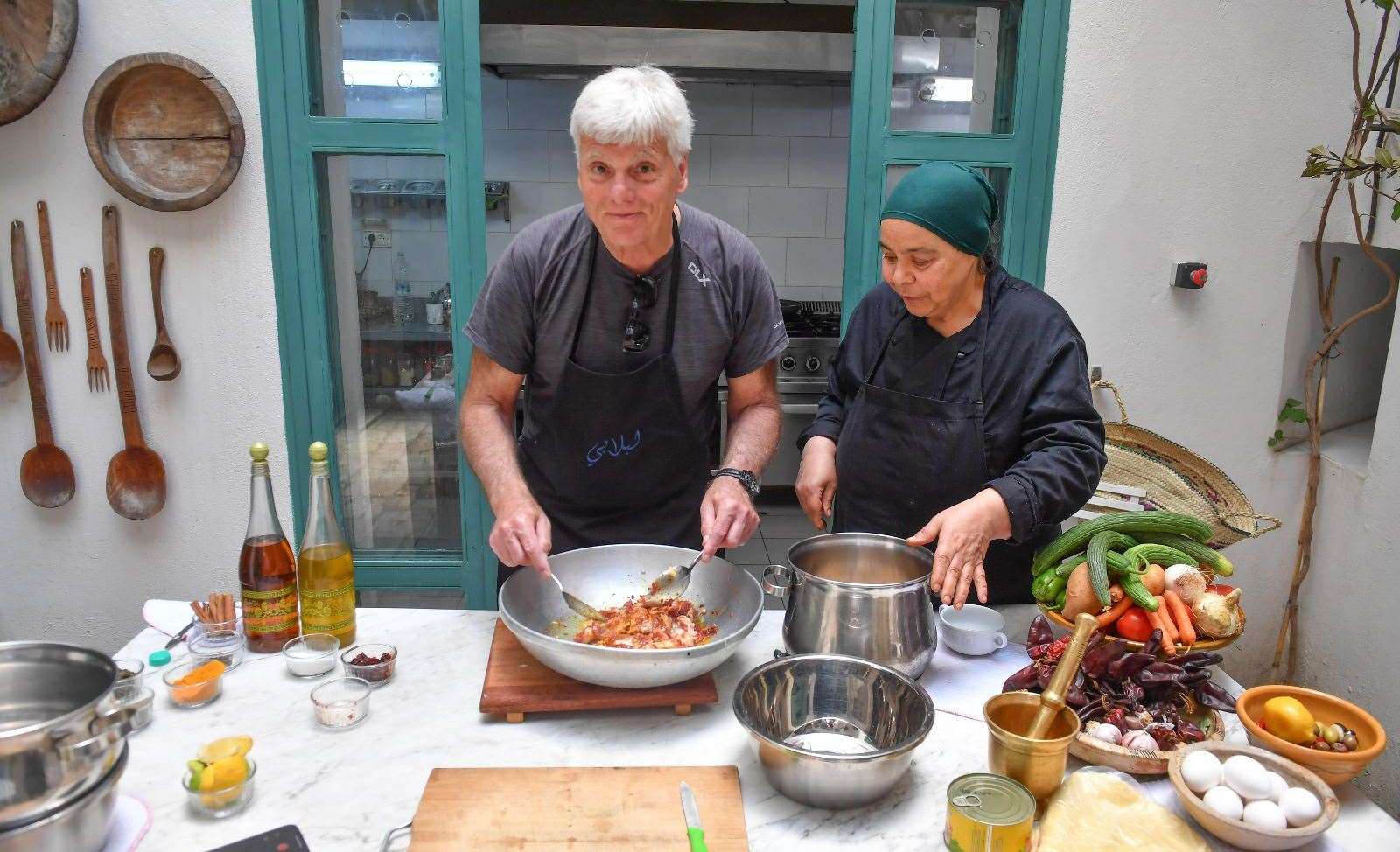 Gerry Warren helps prepare a traditional lamb dish under the watchful eye of a chef who knows what they are doing. Photo: Jules Annan