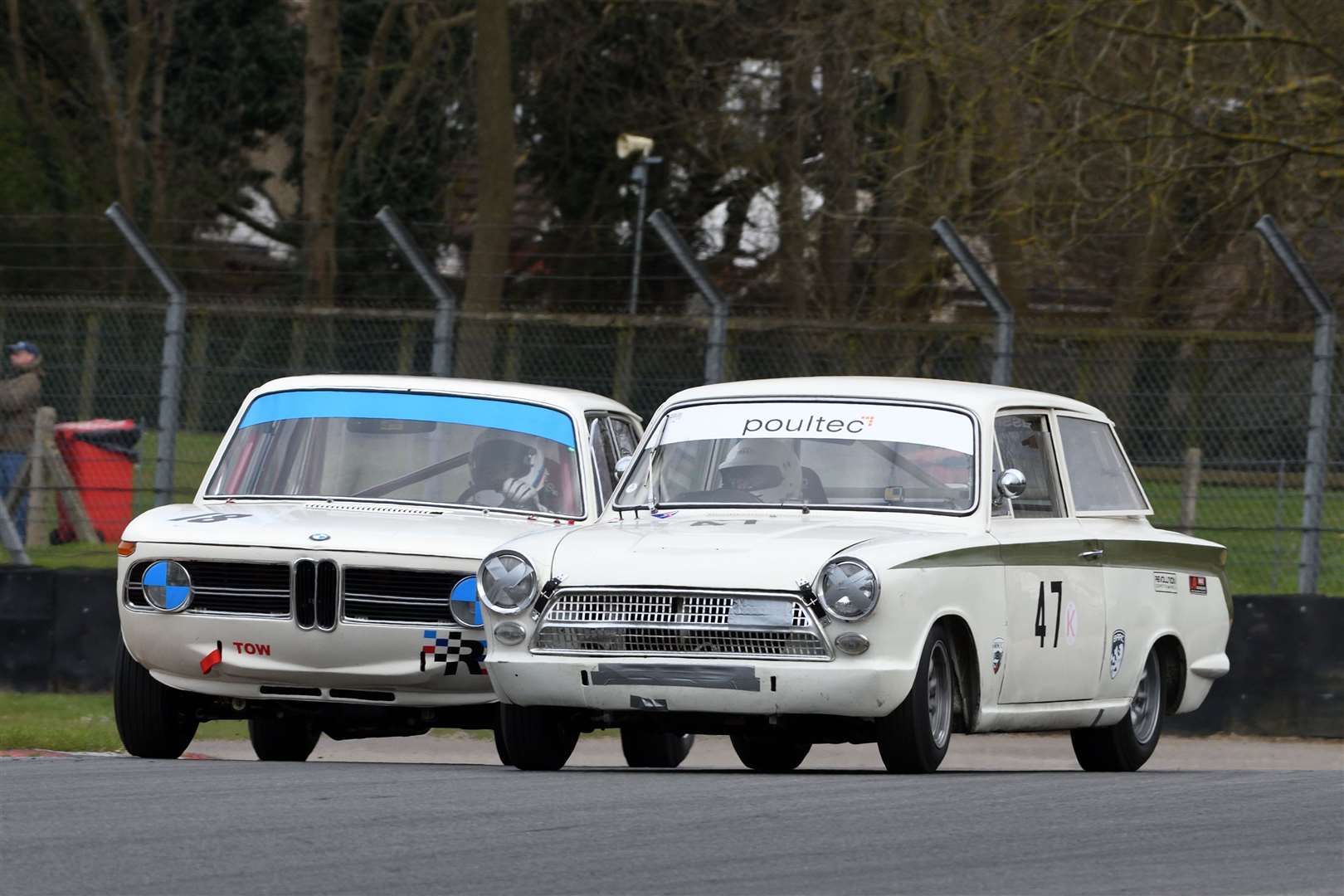 Harry Barton in his BMW 1800Ti and Ford Lotus Cortina pilot Nigel Cox had a race-long battle during the second Historic Touring Car event. They eventually clashed at Paddock Hill Bend with the Cortina being tipped on its side and ending the race two laps early