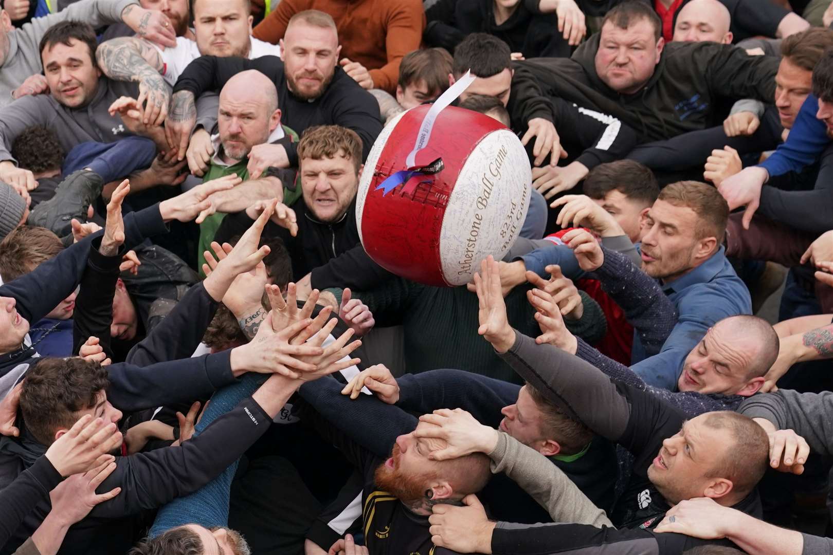 Men take part in the 823rd Atherstone Ball Game in Warwickshire in February. The game honours a match played between Leicestershire and Warwickshire in 1199, when teams used a bag of gold as a ball (PA)