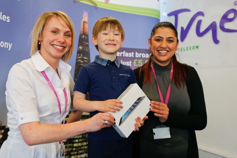 Five-year-old Marley Whyatt, winner of an iPad mini from True Telecom, pictured with staff Milly Heaven and Harri Sandhu