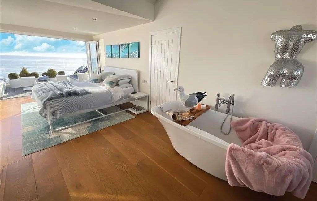 The master bedroom has a stand-alone bathtub and a balcony overlooking the beach. Picture: Fine and Country